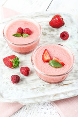 Delicious berry mousse in bowls on table close-up