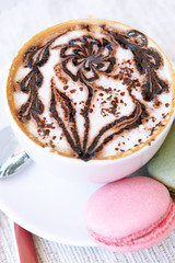 Cup of coffee with cute drawing on table, close up