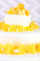 Beautiful wedding cake with oranges on  light background