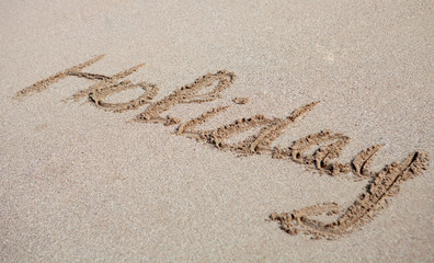 Holiday written on the sand
