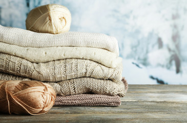 Knitting clothes and yarn on light winter background