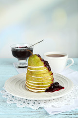 Tasty dessert with sliced pear, cream and berry sauce