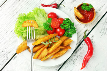 Homemade fried potato on plate on wooden background