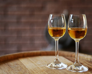 Glasses of wine in cellar with old barrels