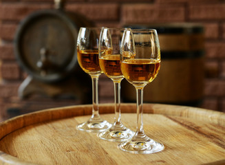 Glasses of wine in cellar with old barrels