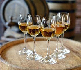 Glasses of wine in cellar with old barrels