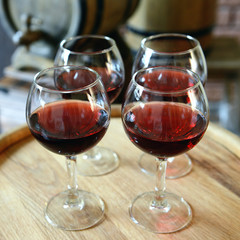 Glasses of wine in cellar with old barrels