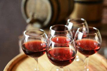 Glasses of wine in cellar with old barrels