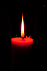 A burning candle in dark.
