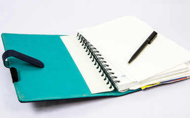 Blue notebook with  pen isolated on white background