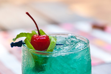 green cocktail with cherry.