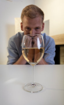 Addicted man looking at glass of wine