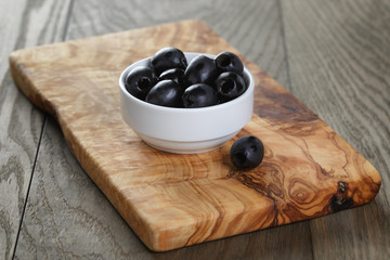 black olives from can in bowl on table