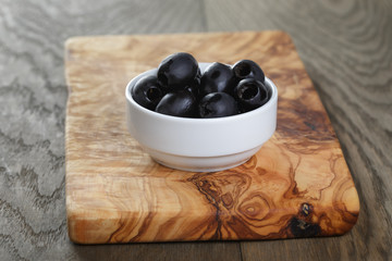 black olives from can in bowl on table