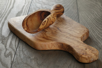 composition with olive wood scoop on top of oak table