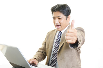 PCで仕事中の笑顔のビジネスマン