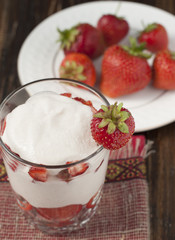 Strawberries with whipped cream in a glass.