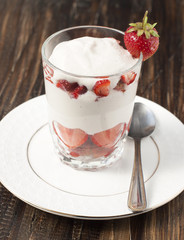 Strawberries with whipped cream in a glass.