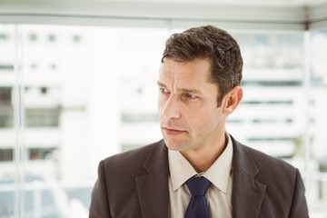 Thoughtful businessman looking away at office