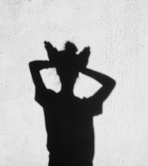 Shadow of girl holding hands on her head