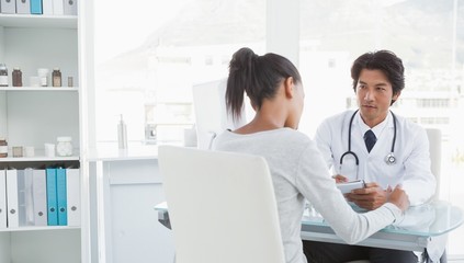 Fototapeta premium Doctor taking notes from patient