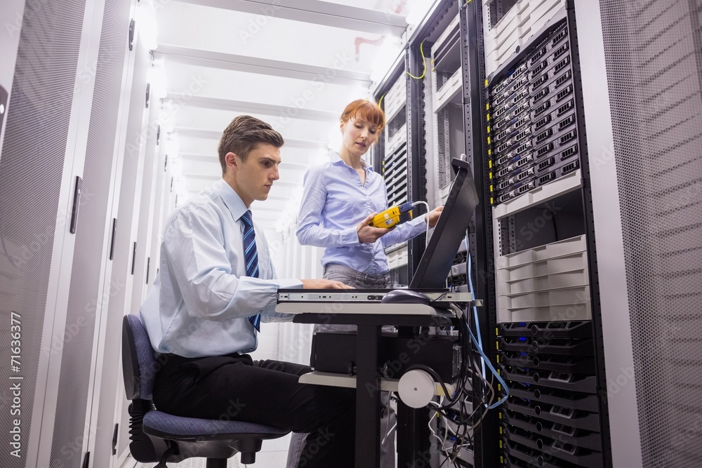 Aufkleber team of technicians using digital cable analyser on servers