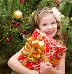 Happy adorable little girl with gift box