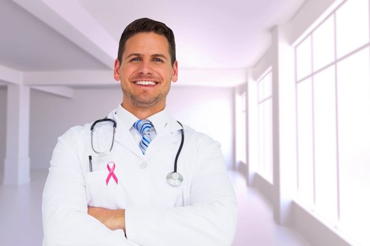 Composite image of handsome doctor with arms crossed
