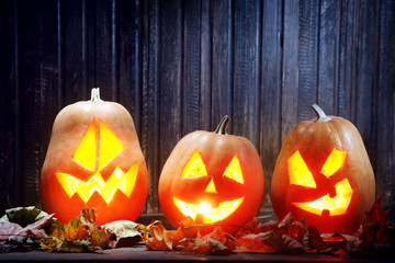 Jack o lanterns  Halloween pumpkin face on wooden background