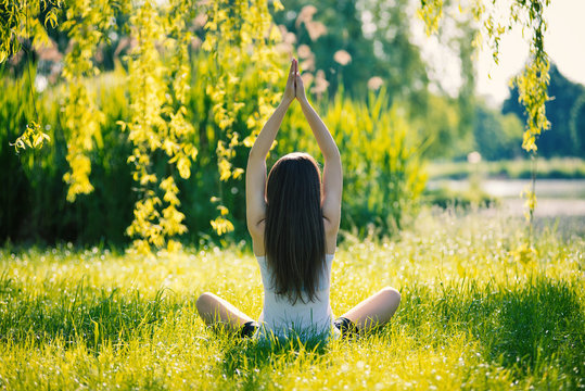 Back View Of Young Woman Doing Yoga, Sitting In Lotus Position O