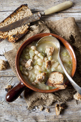 vegetables minestrone soup on bowl with toasted bread and spoon