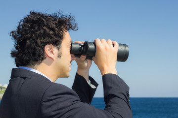 Fototapeta na wymiar businessman looking at the sky with binoculars