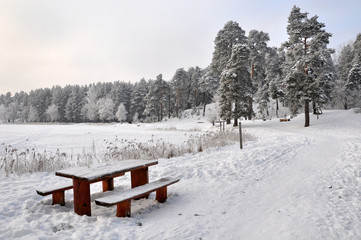 Bench and table in the snow. Winter wonderland in snow covered f