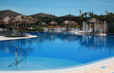 Fototapeta na wymiar Chairs and Pool on a Cuba Resort