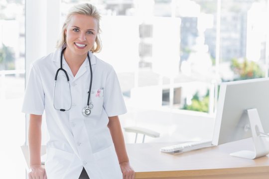 Composite image of attractive nurse leaning on desk