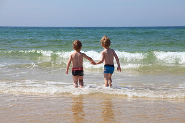 Zwei kleine Freunde gehen im Meer baden