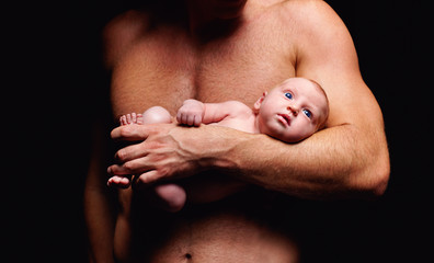 tiny newborn baby in strong father's hand © Olesia Bilkei