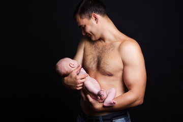 Infant baby boy on his father's arms