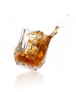 Splashing Whiskey on Glass over White Background
