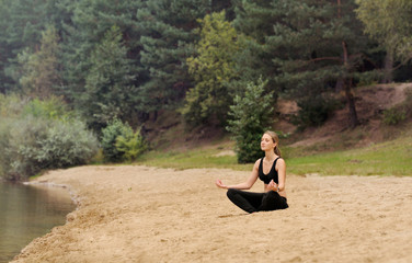 Fototapeta na wymiar young beautiful woman practicing yoga at forest lake, healthy li