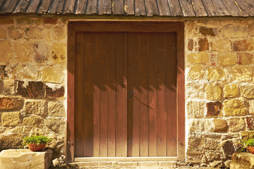 Old stone medieval wall with gate made of wood © ShiningBlack