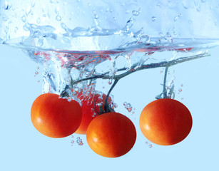 Fresh tomatoes branch dropped into the water background