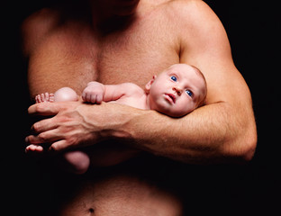 tiny newborn baby in strong father's hand © Olesia Bilkei
