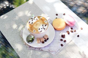 Cup of coffee with cute drawing on table, close up