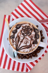 Cup of coffee with cute drawing on table, close up