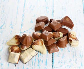 Different kinds of chocolates on wooden table close-up