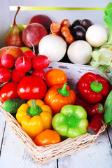 Vegetables in crate and in basket on white wooden box