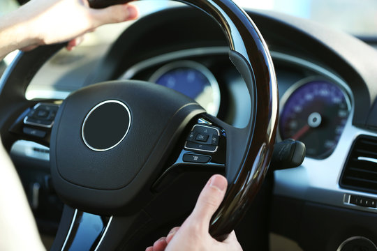 Man's hands on a steering wheel