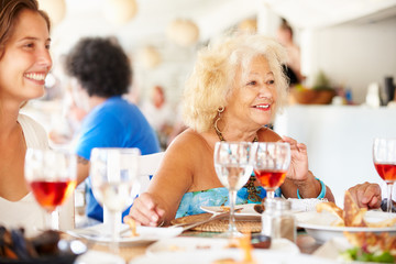 Multi Generation Family Enjoying Meal In Restaurant