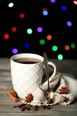 Obraz na płótnie Canvas Cup of tasty hot tea, on wooden table, on shiny background